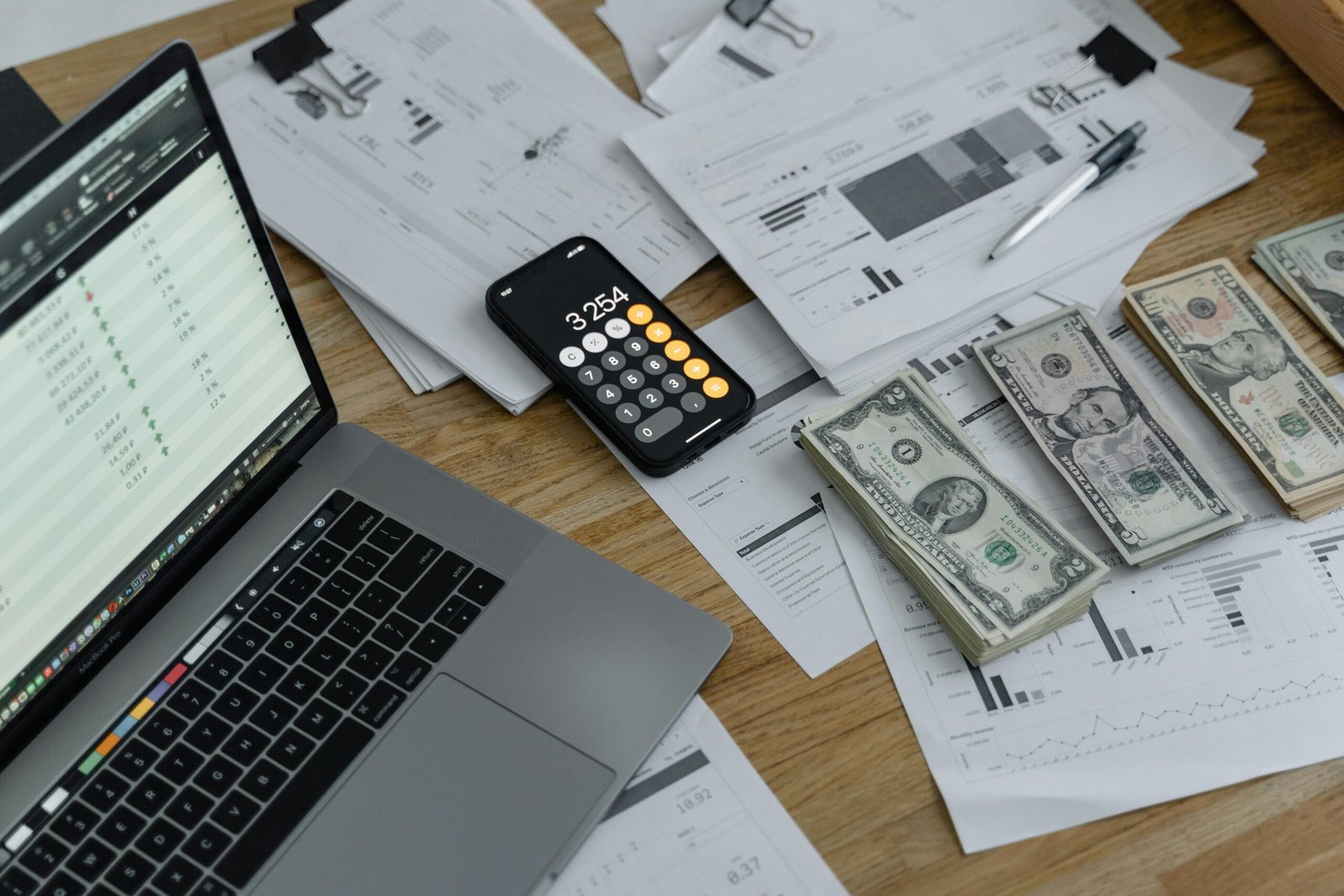 a laptop and money on a table